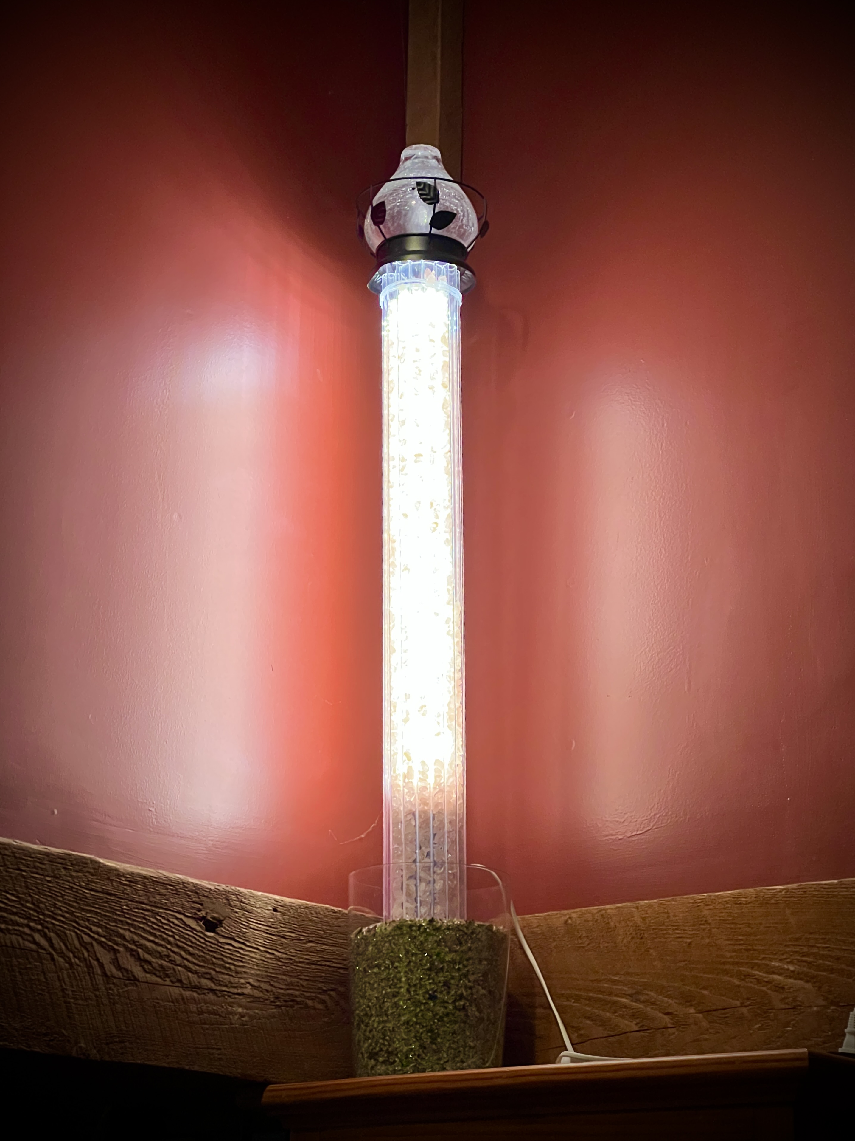 White glowing crystal tube on red wall