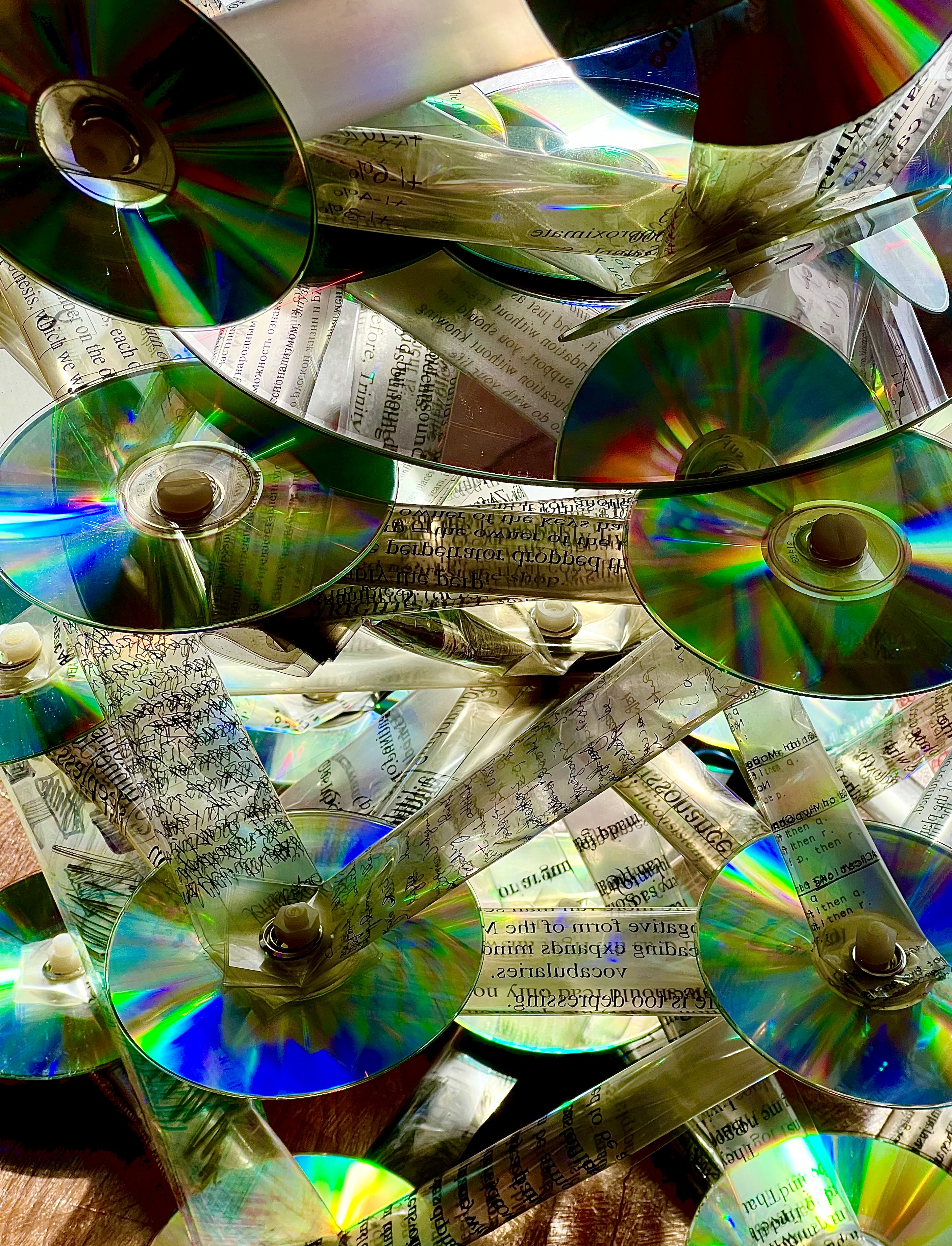 Iridescent CDs woven with text — T.O.E. by Dan Lloyd